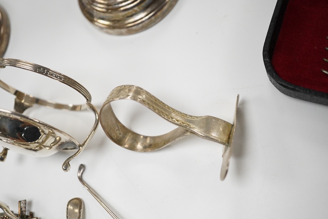 A small quantity of assorted small silver and plated flatware, a small silver stand, a silver napkin ring and a pair of modern silver mounted dwarf candlesticks.